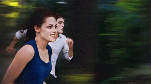 Bella och Edward springer i skogen i Twilight.