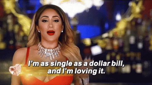 [Image description: a gif of a woman wearing elaborate jewelry and a red dress celebrating her single lifestyle. She says, "I'm as single as a dollar bill, and I'm loving it." Image source: giphy.com]