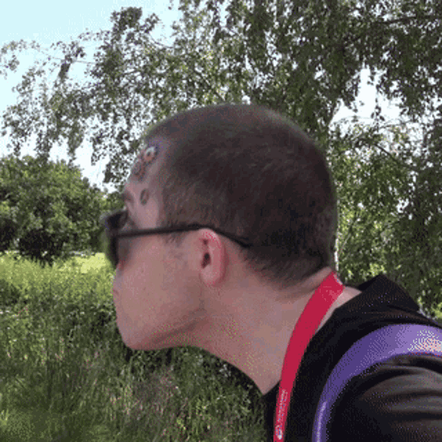 a man wearing sunglasses has a red lanyard around his neck that says ' united states of america ' on it