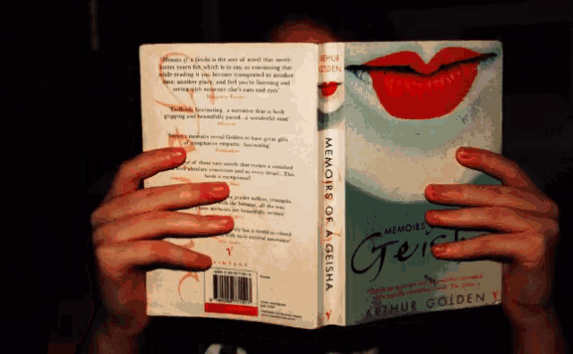 a person reading a book called memories of a geisha