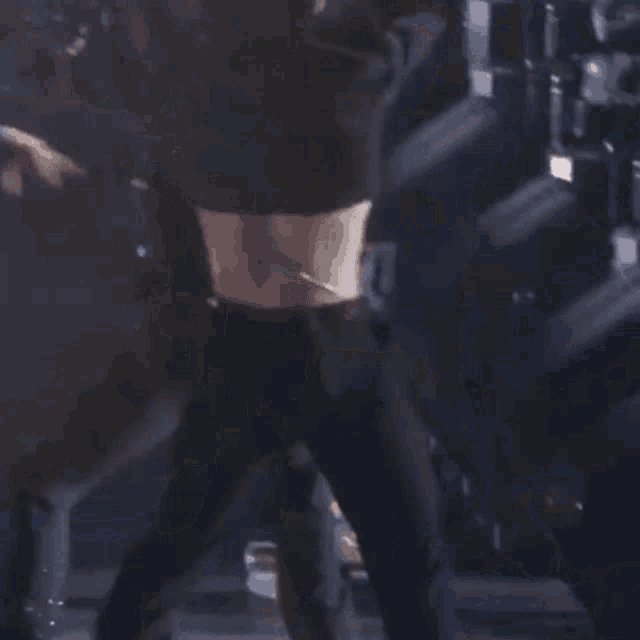 a woman in a black crop top is standing on a stage .