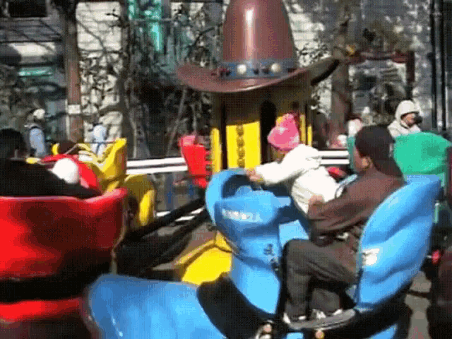 a group of people are riding a carnival ride with a cowboy hat on top