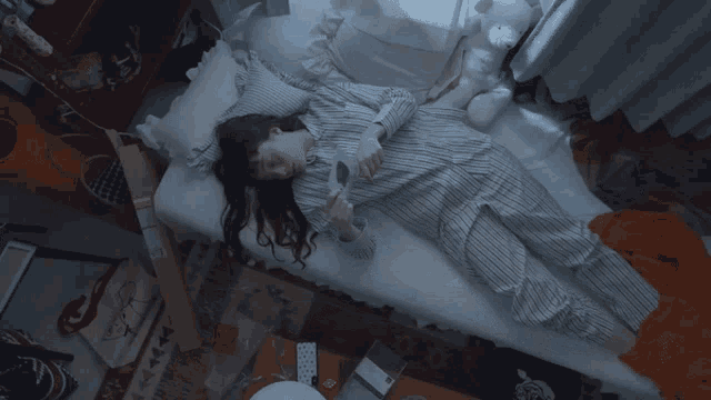 a woman in pajamas is laying on a bed