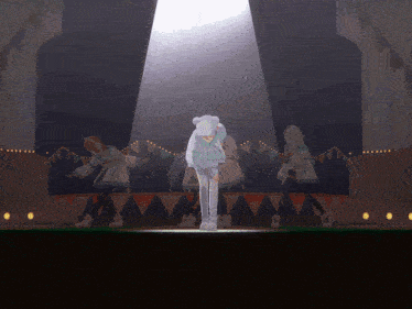a group of girls are dancing on a stage with a spotlight on them