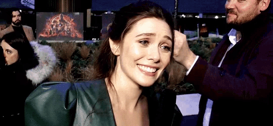 a man is touching a woman 's hair and smiling .