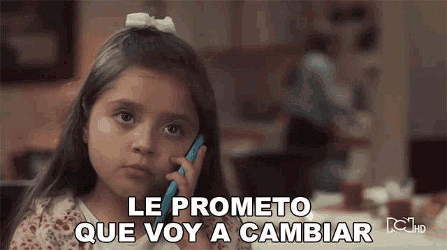 a little girl talking on a cell phone with the words le prometo que voy a cambiar