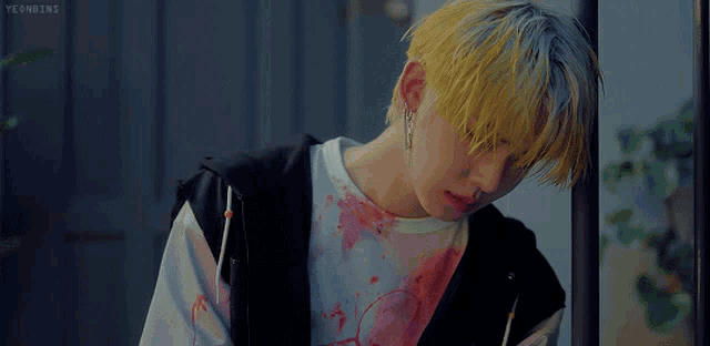a man with yellow hair and a bloody shirt has the word yeonbins written on the bottom