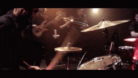 a man is playing a drum set with the letter g on the drum