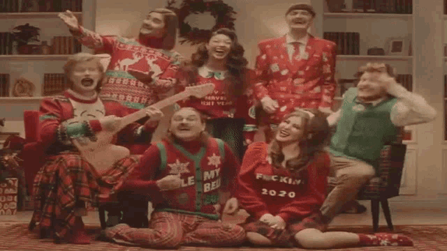 a group of people wearing ugly christmas sweaters including one that says " fuckin 2020 "