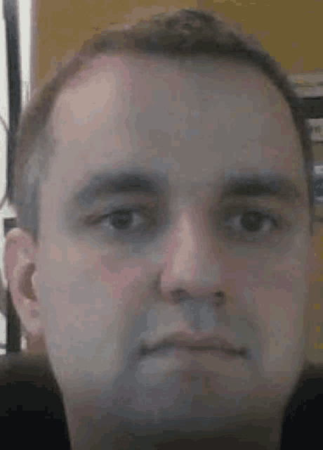 a close up of a man 's face with a serious expression .