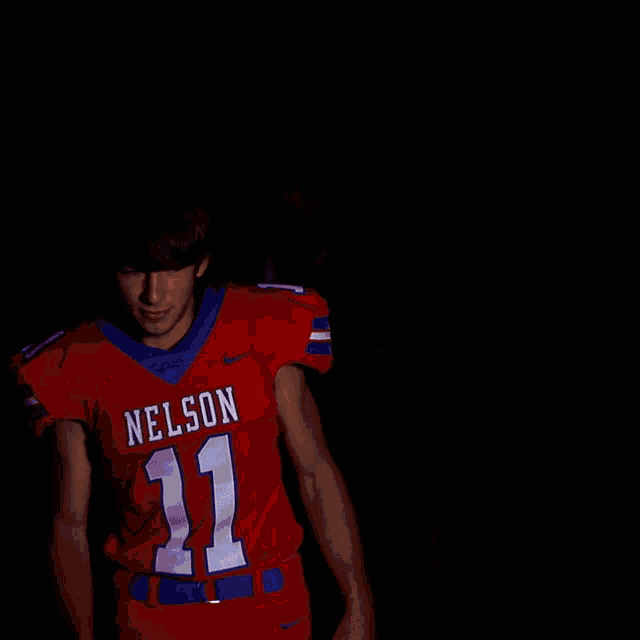 a young man wearing a red jersey that says nelson on it