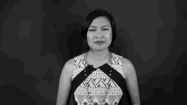 a black and white photo of a woman wearing a shirt with a geometric pattern