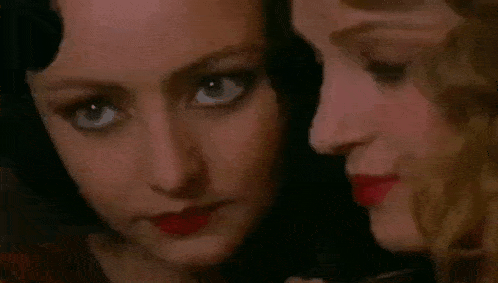 a close up of two women 's faces with red lipstick on .
