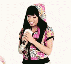 a woman is singing into a microphone while wearing a floral hat .