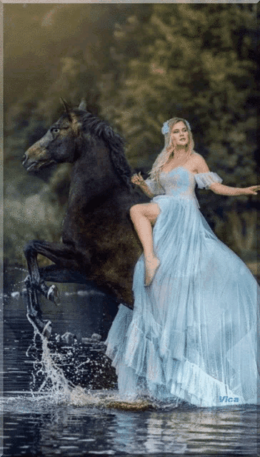 a woman in a blue dress rides a black horse in the water