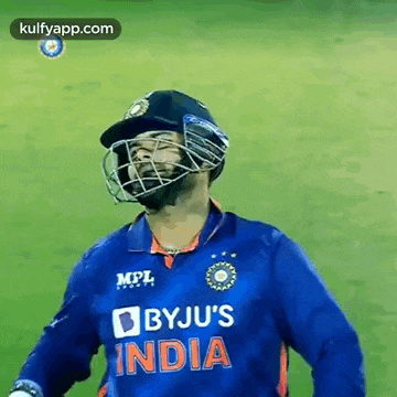 a man wearing a helmet and a blue byju 's india jersey
