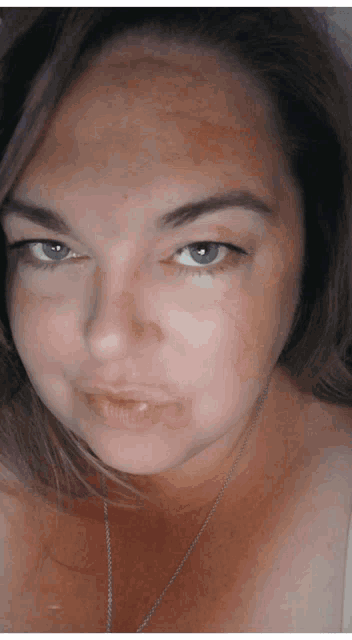 a close up of a woman 's face with a necklace