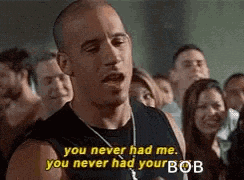 a man in a black tank top is standing in front of a crowd of people .