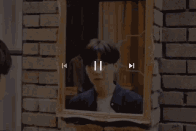 a mirror on a brick wall with a reflection of a chair
