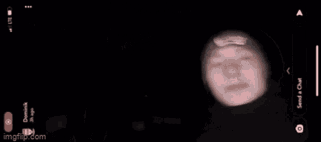 a phone screen shows a person 's face and says send a chat on the bottom