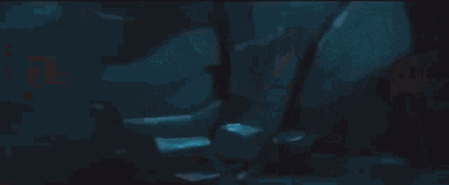 a person is swimming in a pool in a dark room with a red light behind them .