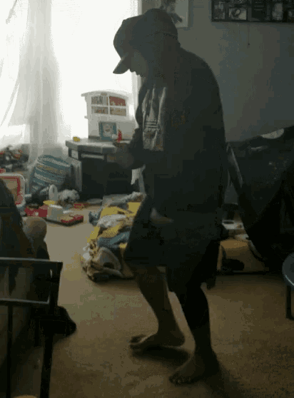 a man in a hoodie is dancing in a room