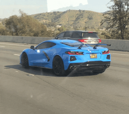a blue sports car is driving down a highway with a license plate that says k