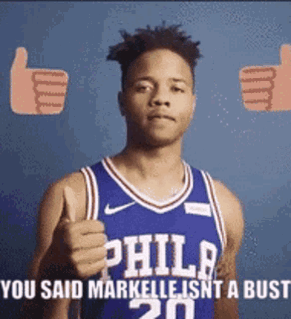 a philadelphia basketball player is giving a thumbs up sign