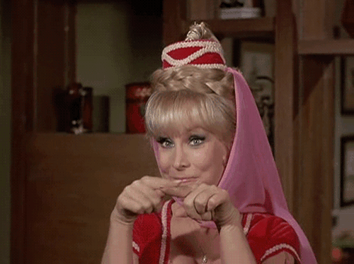 a woman wearing a pink head scarf and a red top is making a funny face .