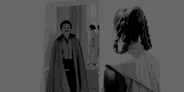a black and white photo of a man and a woman standing next to each other .