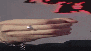 a close up of a person 's hand wearing a ring .