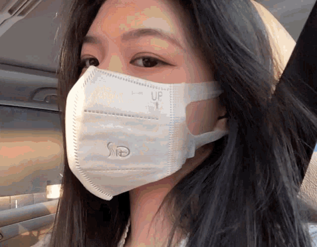 a woman wearing a white face mask with the word up on it