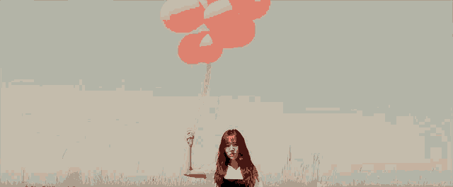a woman is holding a bunch of pink balloons in her hand