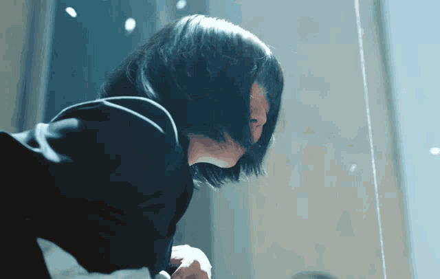 a woman with short black hair is looking down