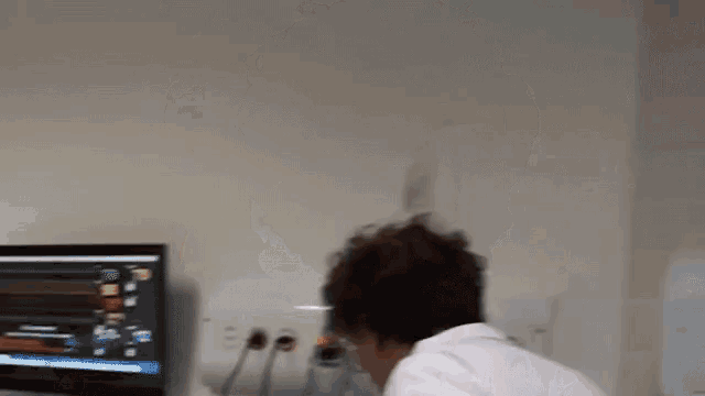 a man in a white lab coat looks at a monitor that says ' ambulance ' on it