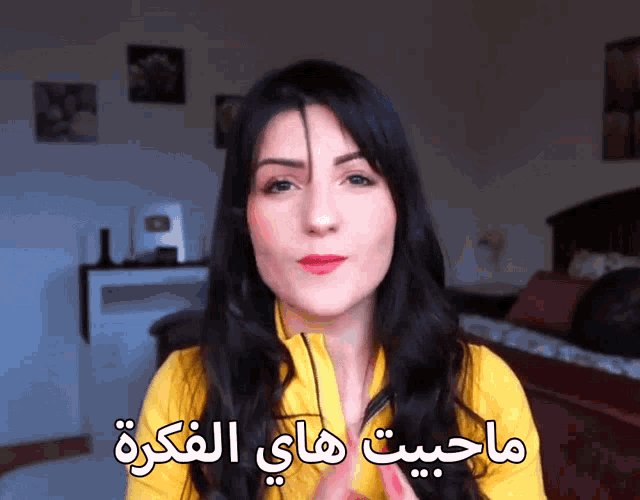 a woman is wearing a yellow shirt and has arabic writing on her face