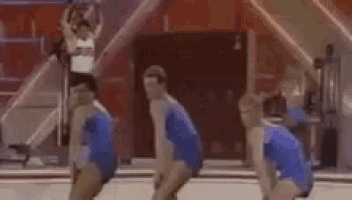 a group of gymnasts are dancing together on a trampoline .