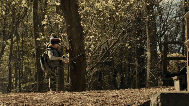 a person standing in the woods with a backpack on their back