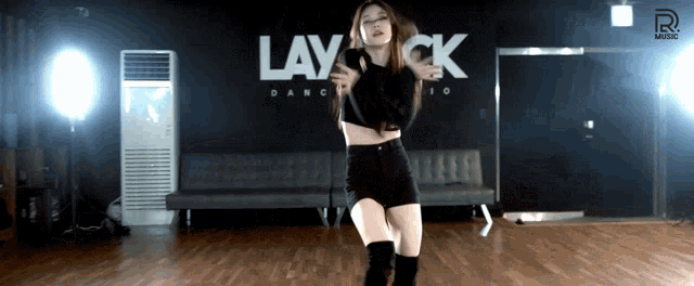a woman is dancing in front of a sign that says lay ck dance studio