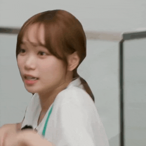 a close up of a young woman wearing a white scrub top .