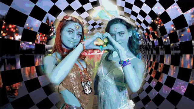 two women making hearts with their hands in front of a checkered background