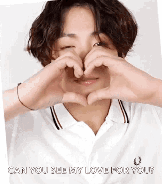 a person is making a heart shape with their hands .