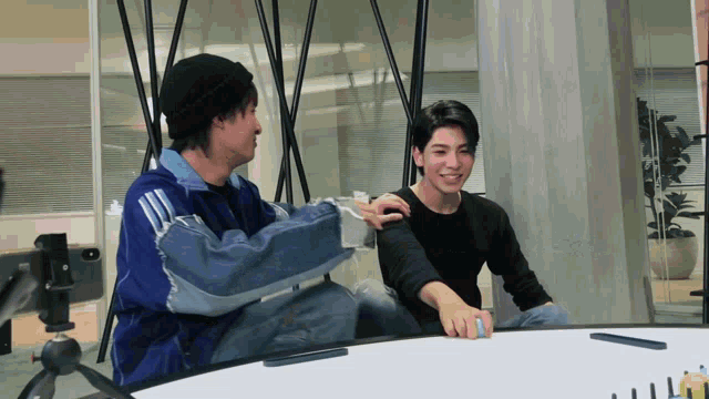 a man in a blue jacket is putting his arm around another man