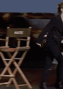 a blurred image of a woman in a black suit walking