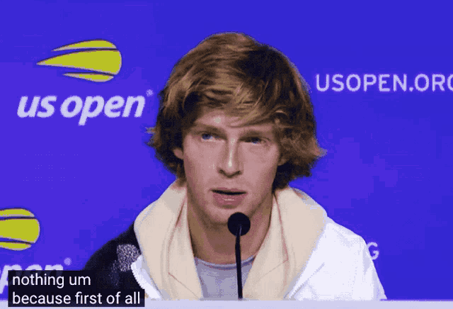 a man stands in front of a us open advertisement