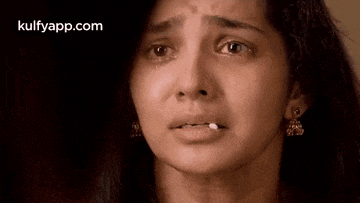 a close up of a woman 's face with tears running down her face .