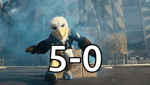 a bald eagle mascot is standing next to a box with the number 5-0 on it