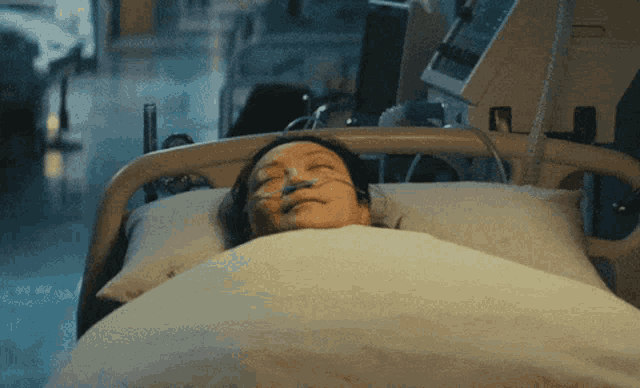 a woman is laying in a hospital bed with an oxygen mask on