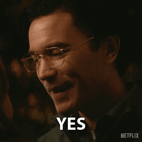 a man wearing glasses is smiling and the word yes is on his face
