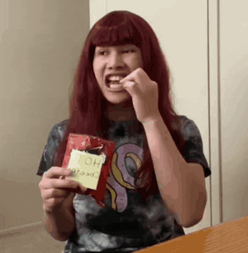 a girl with red hair is holding a bag of chips that says oh